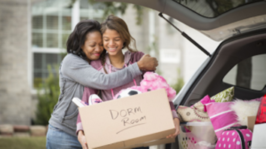 mother hugging daughter going to college dorm